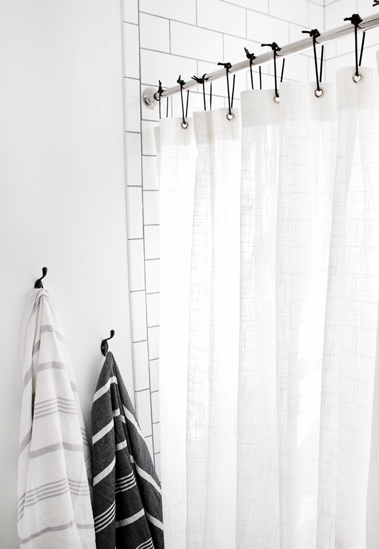 white shower curtain black hooks minimal bathroom